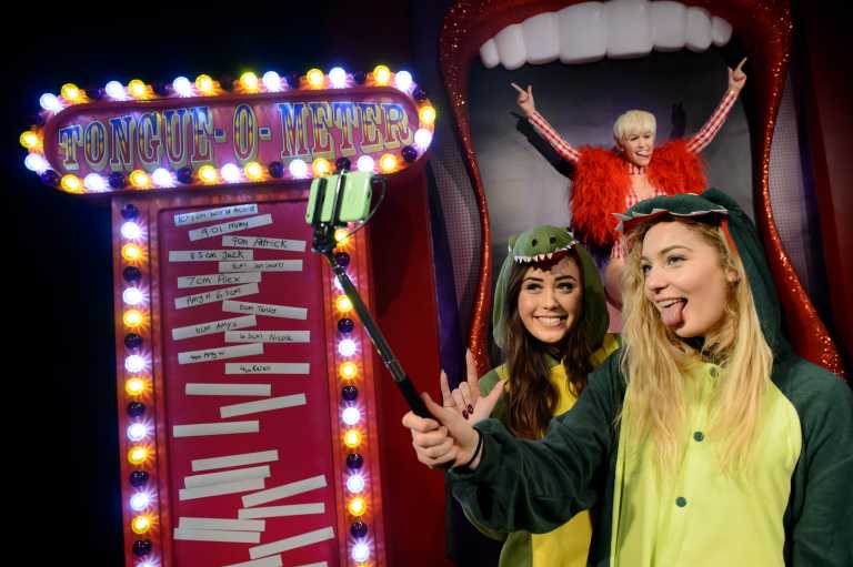 MILEY CYRUS SLIDES INTO MADAME TUSSAUDS LONDON ON A GIANT TONGUE!